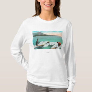 Beskåda av surfarear stiger ombord ridning, ett tee shirt