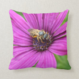 Bi på en blommadekorativ kudde