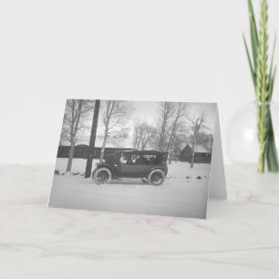 Bil med en julgran som binds till huven helgkort