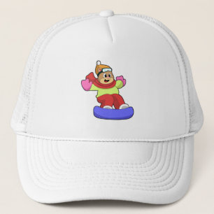 Björn vid snowboardingbombord med snötbord keps