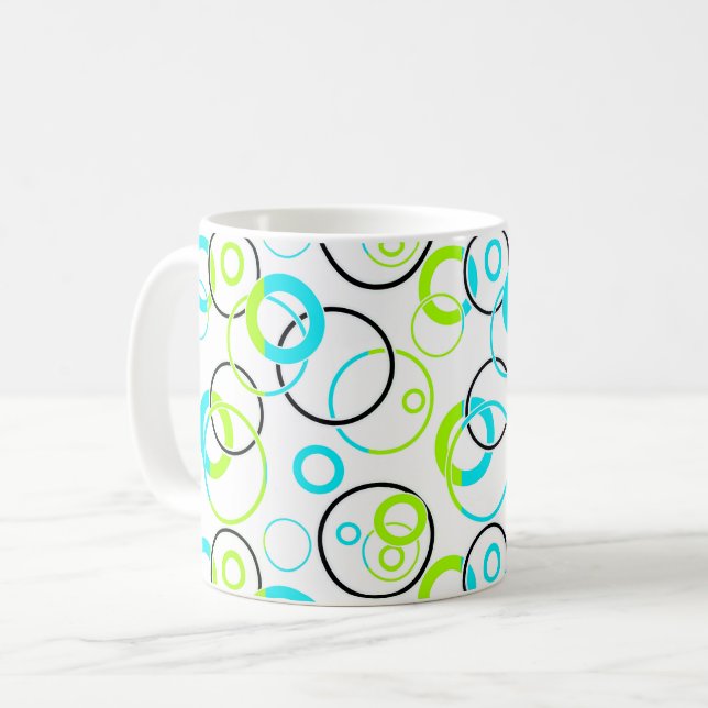 blå gröna och svarta ringar och cirklar på vit  kaffemugg (Framsida vänster)