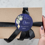 Blå guld, vit buske jul runt klistermärke<br><div class="desc">För en julomslutning av party favors eller gåva. En vit,  ojämn färgad bakgrund. Dekorerad med vita och guld baublar och lite grej och en gräs-kon. Anpassa och lägg till ditt namn,  år. Text: God jul</div>