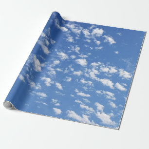 Blå himmel och vita moln som omsluter papprare presentpapper