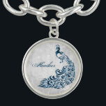 Blå peacock Löv Vine Personlig Charm Bracelet Armband<br><div class="desc">Anpassa en unik gåva till dina brudtärnor med en Blue Peacock Löv Vine Personlig Charm Bracelet. Bracelet-konstruktionen har en lätt grått-grym bakgrund med en pulserande blå påk med en löv-försköning. Anpassa med ditt brudgumms namn. Ytterligare bröllop-kontorsmaterial och presenter som finns tillgängliga med den här utformningen också. Behöver du hjälp med...</div>