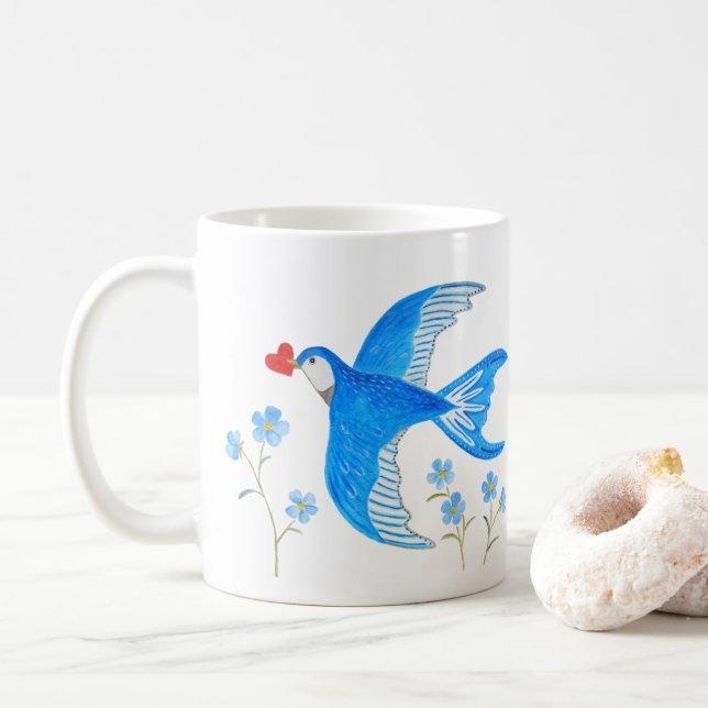 Blå svala som bär röd hjärtfågel i folkkonst kaffemugg (Med munk)
