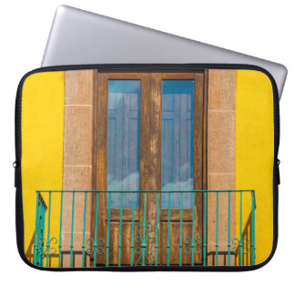 Blå trädörr på gult betong byggnad laptop fodral