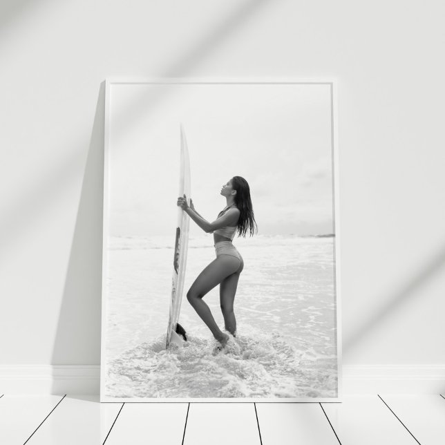Black and White Surfer Girl på Beach Poster (Black and White Surfer Girl on the Beach Poster in white frame on wooden floor.)