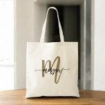 Black Guld Modern Script Monogram Namn Tygkasse<br><div class="desc">Bär med dig dina essentiella saker i stil med den moderna skribenten Svarta och Guld, Monogram Namn Tote Bag. Med en elegant svart arbetsyta med ett fet guld-monogram i ett modernt typsnitt blandar den här väskan elegans och funktionalitet. Det är tillräckligt rymligt för att handla, arbeta eller använda varje dag....</div>