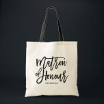 Black Hand Lettering Matron of Honor Tote Bag Tygkasse<br><div class="desc">Modern och klassisk väska med svart MATRON OF HONOR-handskript. Anpassa genom att lägga till mottagarna namn eller hashtaggen i bröllop. Perfekt som gåva till bröllopsfesten eller brudens sida.</div>