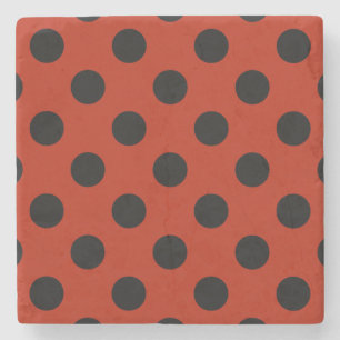 Black polka dots på röd stenunderlägg