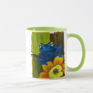 Blåttgrodan som kopplar av på blomma, och träd mugg