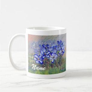 Blåttvildblommar i en fältkonstmålning kaffemugg