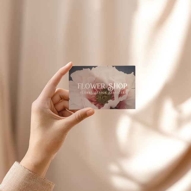 Blomdesignbutik kort (Dusky blue business card with blush pink serif text and floral design accents)