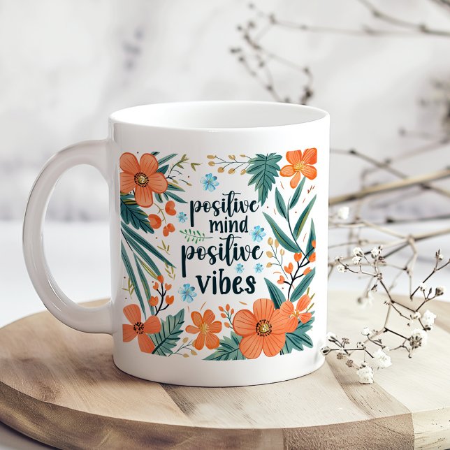 blommigt av Orangen "Positive Mind Positive Vibes" Kaffemugg ("Positive Mind Positive Vibes" Orange Floral Coffee Mug on a boho kitchen table with dry flowers)