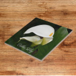 Blommigten Two White Calla Lilies Kakelplatta<br><div class="desc">För blomma och vegetabiliskt älskare! Keramiskt plattor som har en fotobild av två,  vackra,  vita Calla Lilies och deras grönt löv. En underbar,  blommigt design! Markera din ruta storlek. Gör en söt köksbagge!</div>