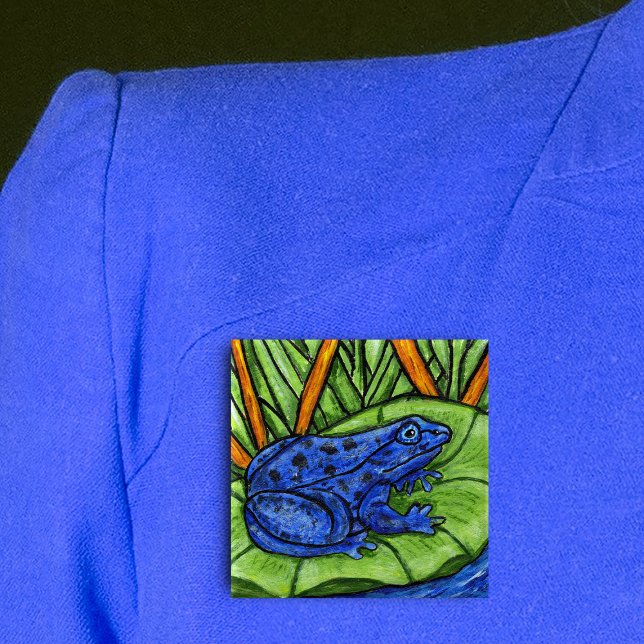 Blue Poison Frog Button Knapp (Vibrant blue frog on green lily pad in water with grass and reed plants on square pin back button.)