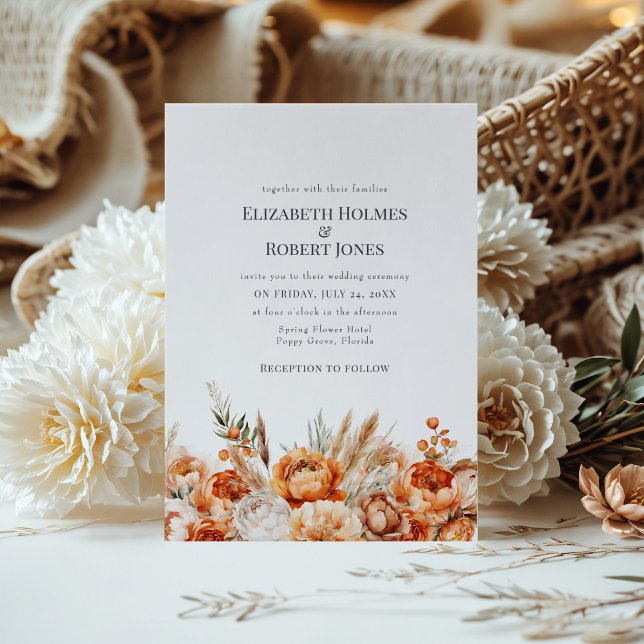 Boho korall- och persikafärgade torra blommor bröl inbjudningar (Boho Coral and Peach Dry Flowers Wedding Invite on a table with a boho flower bouquet.)