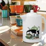 Bokar Cat Tea Cute<br><div class="desc">En söt svart och vit katt som sover på en hög av bokar med en grönt tekanna och en kopp te.</div>