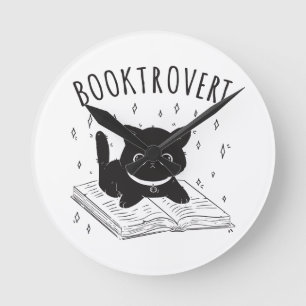 Booktrovertkatt med bok och stjärnor rund klocka