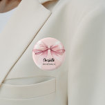 Bridesmaid bow rosa namn bricka knapp<br><div class="desc">En mjuk färgad för  rosa. Dekorerad med en stor båge. Anpassa och lägg till ditt brudgumms namn. Svart handskript i stil.</div>