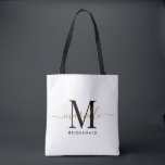 Bridesmaid Gift Guld Monogram White Tygkasse<br><div class="desc">Den här Bridesmaid tote-väskan har ett handskrivet typografiskt monogram med vita och svarta skript med dekorationer mot en dammig bakgrund i ro. Presentera dina brudtärnor med en tärning för att bära artiklar på bröllop-dagen och presenteras traditionellt vid repetitionsmiddagen eller före.</div>