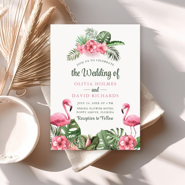 Bröllbjudan för tropisk flamingo-blomma i vattenfä inbjudningar (Watercolor Tropical Flamingo Wedding Invitation on a sunny neutral boho table with dry palm leaf.)