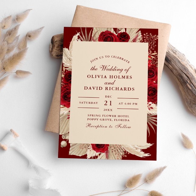 Bröllopsinbjudan till Burgundy Tropical Ro Inbjudningar (Burgundy Tropical Roses Wedding Invitation on a table surrounded with pampas grass.)