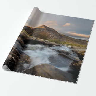 BROWN MOUNTAIN NEAR BODY OF WATER UNDER CLOUDY SKY PRESENTPAPPER