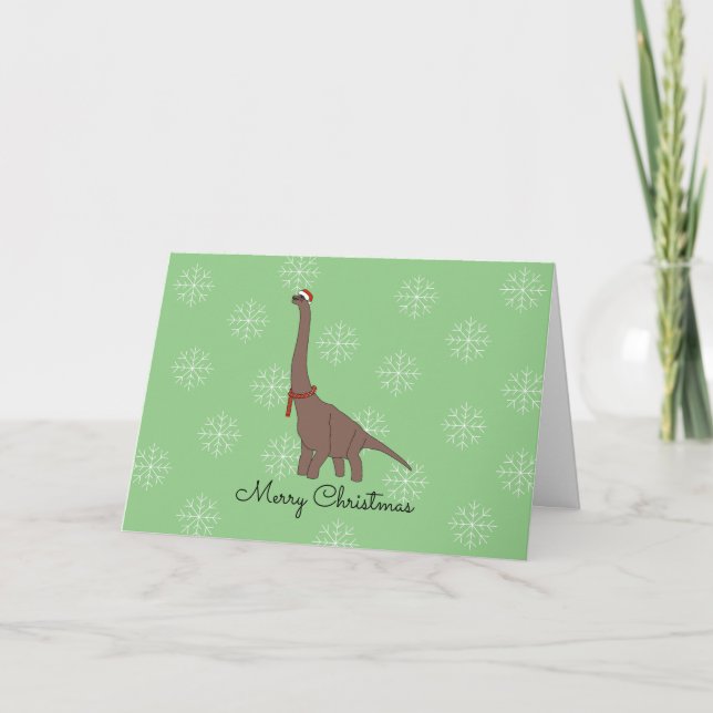 Brun dinosaur med jultomtehatt snöflingor jul helgkort (Framsida)