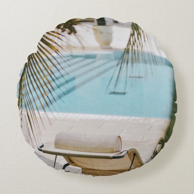 Brun och svart armstol bredvid simmande bassäng un rund kudde (Framsidan)