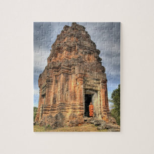 Buddhistmunk stående i dörröppningen till ett temp pussel