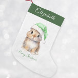 Bunny i Grönt Santas Hat Personlig Liten Julstrumpa<br><div class="desc">Personlig jultomten Stocking, perfekt för dina små i julhelgen. Den här fina strummet har en söt, liten bunny med en grönt Santa's hatt täckt med snö. Det kan vara personlig med ditt barns namn. Håll den på manteln eller i ditt barns sovrum för att få en festlig beröring till ditt...</div>