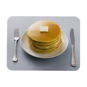 Bunt av pannkakor med smör på en plätera magnet