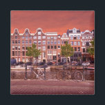 Byggnad, kanal, cyklar i Amsterdam, Nederländerna Magnet<br><div class="desc">Typiskt byggnad,  kanal och cyklar i Amsterdam per dag,  Nederländerna</div>