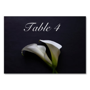 Calla lilies på en mörk bakgrund bordsnummer