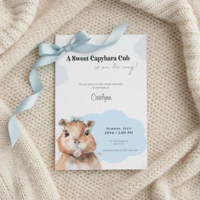 Capybara Baby Shower • Blue Bow Theme Inbjudningar (Baby shower invitation with capybara and blue bow on cream knitted blanket, soft neutral tones.)