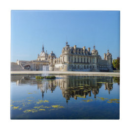 Chateau de Chantilly med reflexion i en damm Kakelplatta