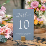 Chic Script Dusty Blue Wedding Reception Bordsnummer<br><div class="desc">Chicens dammiga blå bröllopsskylt med bordsnumret "bord" i ett snyggtens vita kalligrafiskript med dekorationer, bordsnumret i elegantens vita serif-typografi, ditt första namn gått med av ett hjärta och ditt mottagningsdatum. Skapa varje bordsnummer-tecken och lägg till i din kundvagn en i taget, och checka sedan ut gången så att alla nummer...</div>