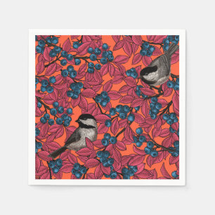 Chickadee-fåglar på grenar på blåbär på orange pappersservett