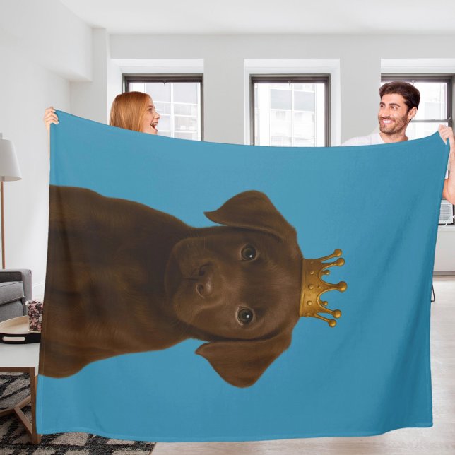Chocolate Labrador Puppy i Krona Cute Guld Fleecefilt (Chocolate Labrador Puppy in Gold Crown Cute Fleece Blanket by Ricaso. Choc lab pup dog on blue)