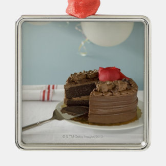 Chokladtårta med den saknade skivan på bord, julgransprydnad metall