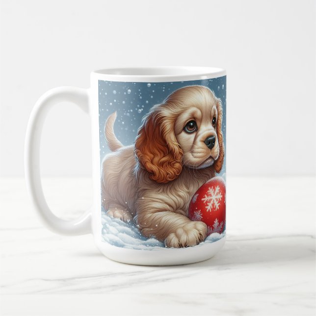 Cocker Spaniel-valp som vilar på snö med en boll Kaffemugg (Vänster)