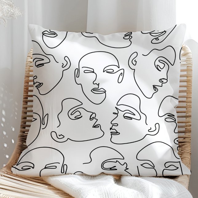 Contemporary Line Art Teckning Ansikte Kudde (Contemporary Line Art Drawing Faces Throw Pillow on a sunny rattan armchair.)