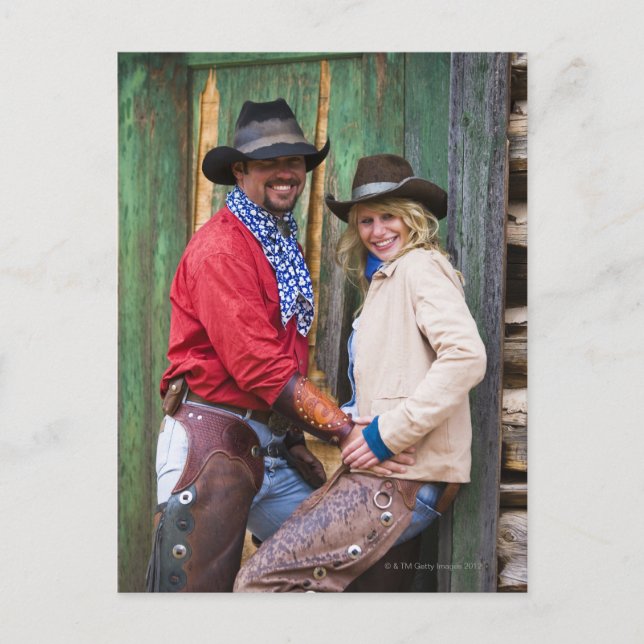 Cowboy and cowgirl holding hands in front of an vykort (Framsida)