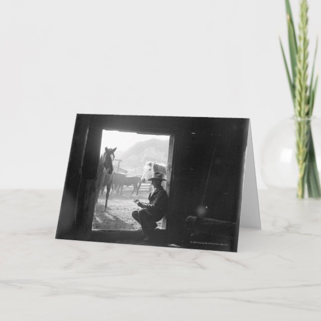 Cowboy i en dörröppning med hästar kort (Framsida)