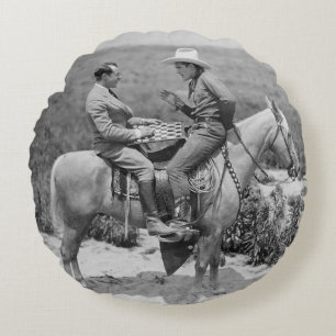 Cowboyen och affärsmannen spelar checkers på häste rund kudde