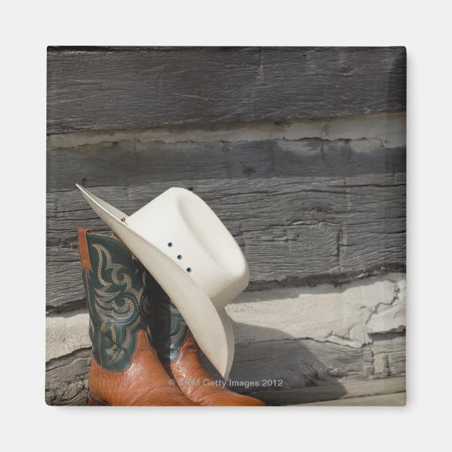 Cowboyhatt på cowboystövlar utanför loggstugan magnet (Framsidan)