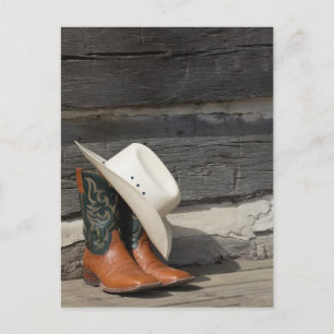 Cowboyhatt på cowboystövlar utanför loggstugan vykort