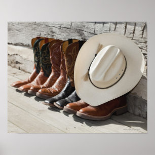 Cowboyhatt på rad av cowboystövlar utanför en logg poster