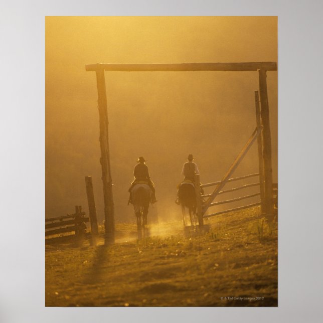 Cowboys åker genom grind i skymning poster (Framsidan)